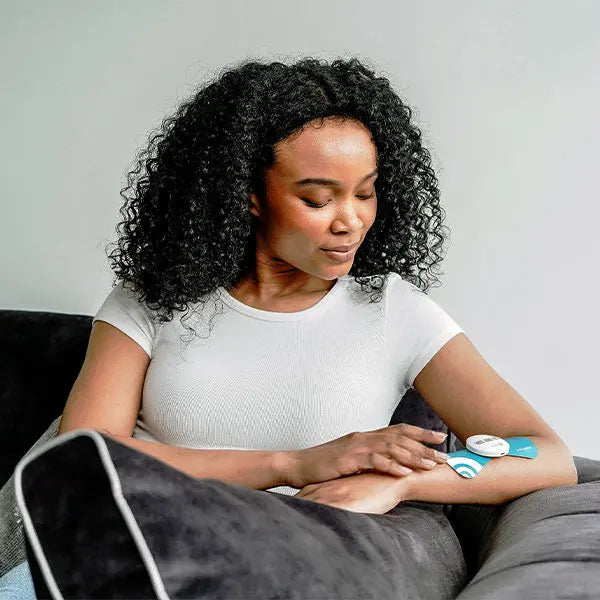 Woman wearing PainGone Easy on her arm while relaxing