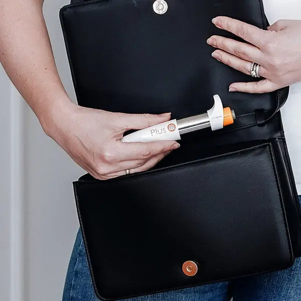 Woman taking the pocket-size PainGone Plus pen out of her handbag